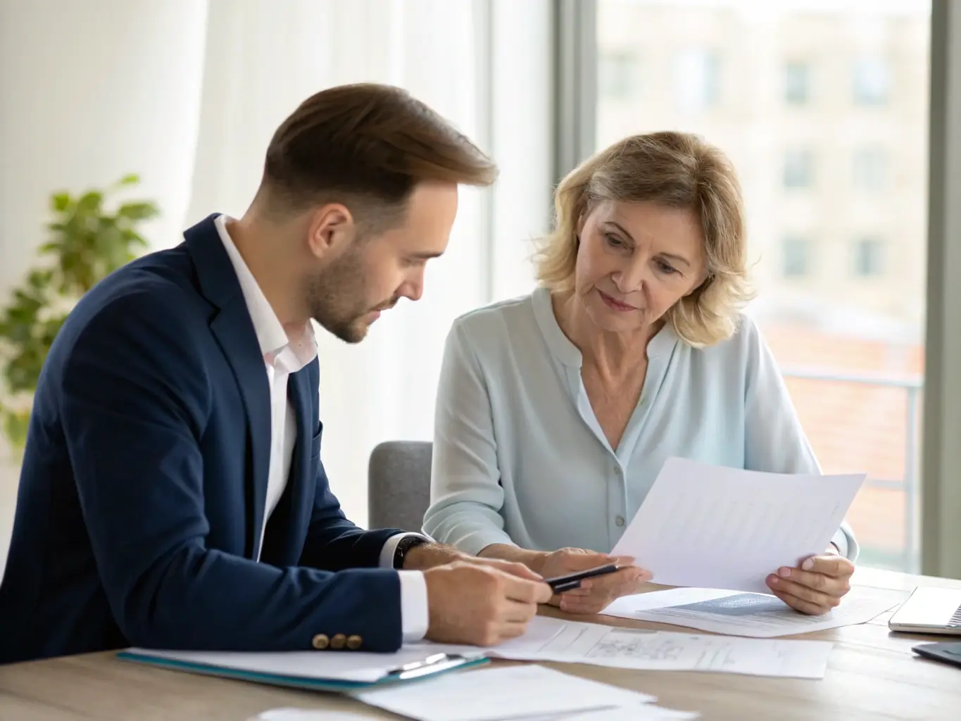 A consultant in a meeting, reviewing financial documents with a client, emphasizing strategic financial planning.